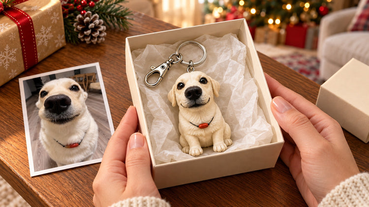 Cream-colored dog keychain in an open Christmas gift box beside its reference photograph