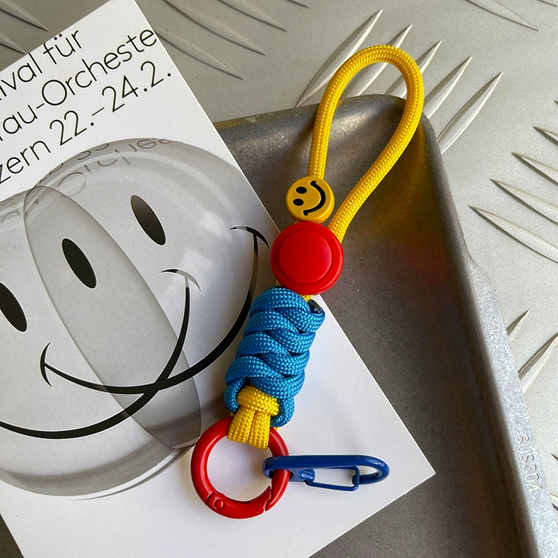 Colorful keychain with smiley face design on a newspaper background
