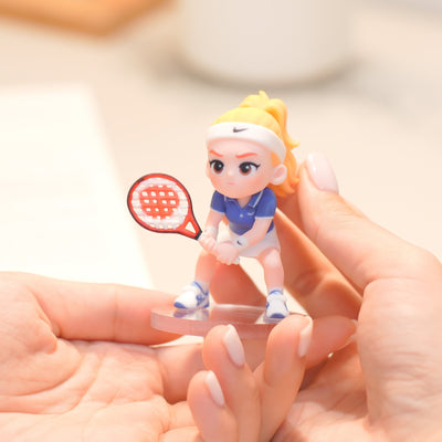 Figurine of a person holding a phone next to a 'Lucky Pop!' box on a table.