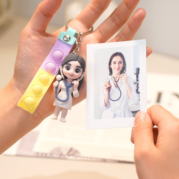 Keychain with a small figure of a doctor held by a hand, next to a photo of a person in a medical setting.