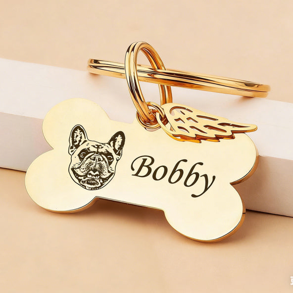 Front view of a gold engraved dog bone keychain personalized with a pet's name and a small paw print